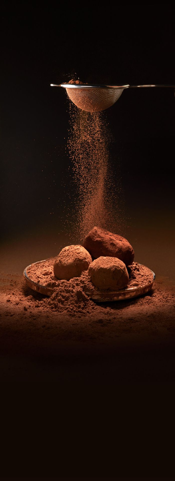 Jeff de Bruges reclamefoto truffles met cacao poeder