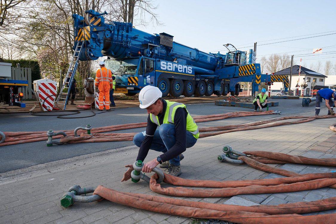 Sarens hydraulische kraan met operator en hijsriemen