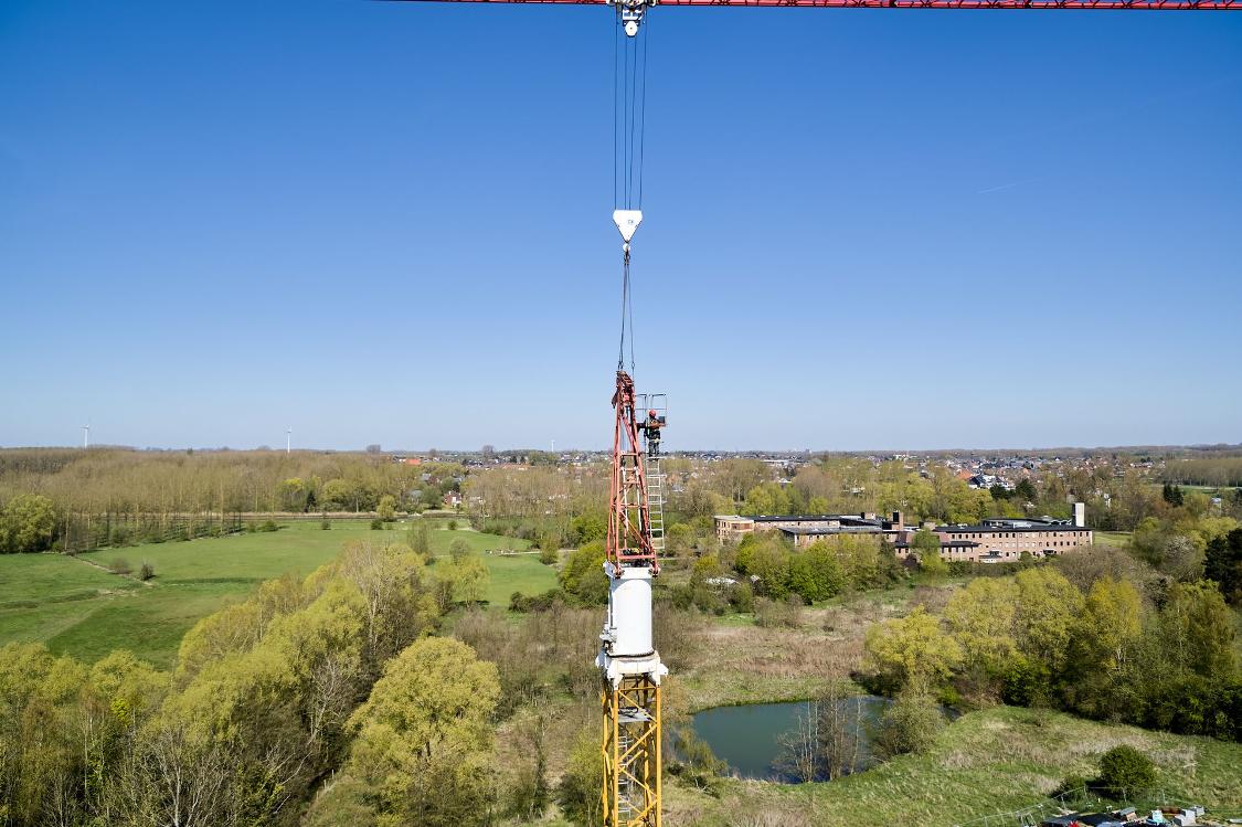 Dronbeeld van operator aan het werk aan top van een torenkraan